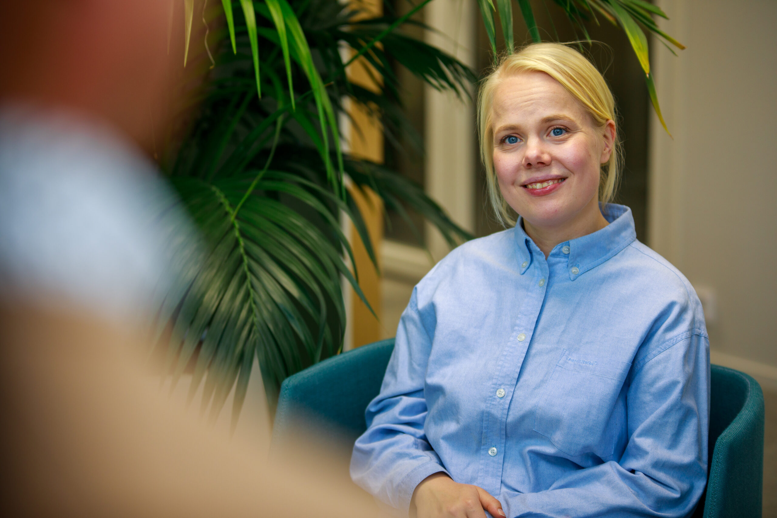 Hymyilevä yrittäjä istuu toimistolla